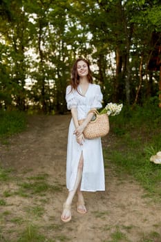 a woman in a light dress smiles while standing in the park on the grass enjoying her outdoor recreation. High quality photo