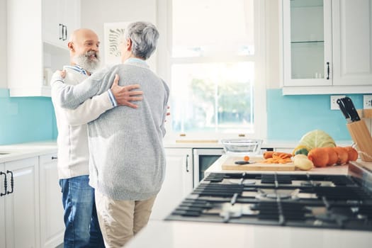 Dance, love and a senior couple in the kitchen of their home together during retirement for bonding. Happy, smile or romance with a mature man and woman pensioner dancing while having fun in a house.