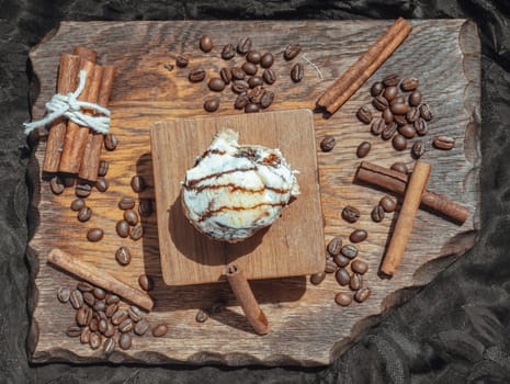 Chocobon (Soft chocolate bun) topped with rich cream cheese frosting and Cinnamon with Coffee beans on wooden with dark background. Top view, Selective focus.