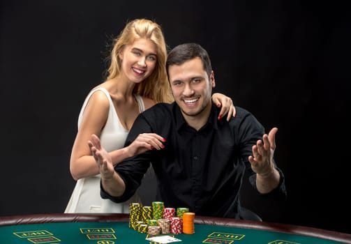 Young couple playing poker and have a good time in casino, woman embracing man.