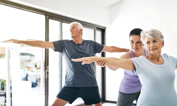 Yoga really does benefit anyone and everyone. an instructor guiding a senior couple in a yoga class