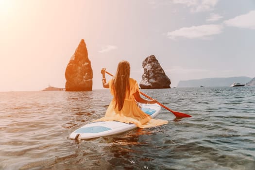 Close up shot of beautiful young caucasian woman with black hair and freckles looking at camera and smiling. Cute woman portrait in a pink bikini posing on a volcanic rock high above the sea