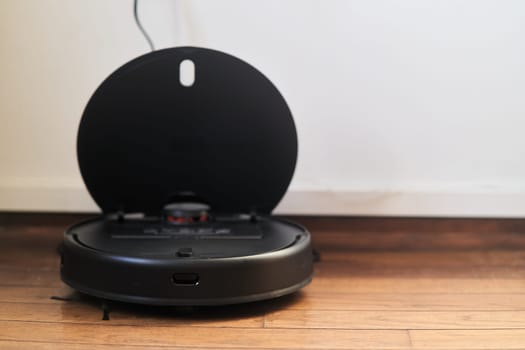 Belgrade, Serbia December 15, 2022: Black robotic vacuum cleaner is charging. High quality photo