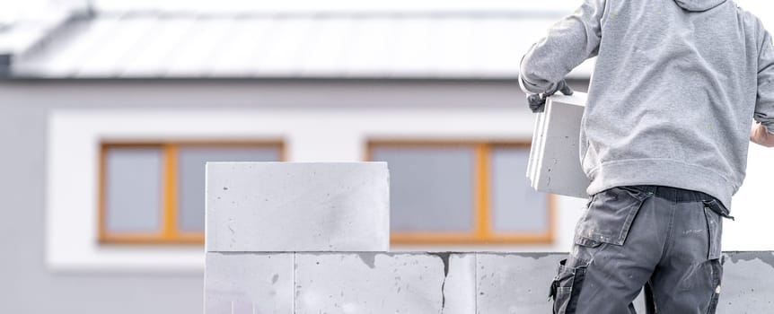 a mason builds a wall from concrete blocks. High quality photo