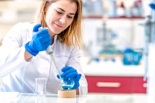 young female scientist conducts chemical experiments in a research laboratory.