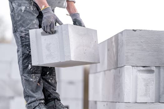 a mason builds the wall of a house from concrete blocks. High quality photo