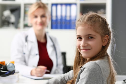 Portrait of child girl at reception at the pediatrician doctor in clinic. Medical examination of children and insurance