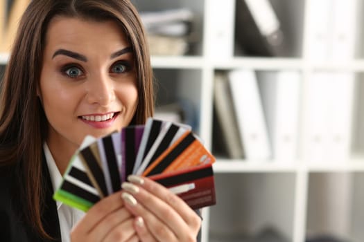 Portrait of young beautiful woman holding bank plastic credit cards. Choice of banking services and approved loan