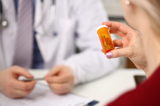 Doctor hands over medical pills to patient in clinic office. Prescribing antibiotics for pneumonia or hormone pills for women