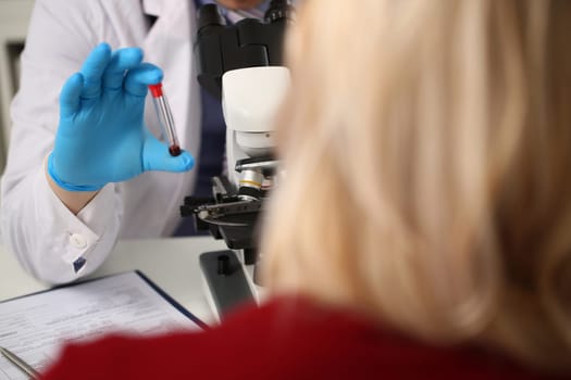 Laboratory assistant prepares blood for analysis for antibodies and viruses. Patient taking blood test in clinic
