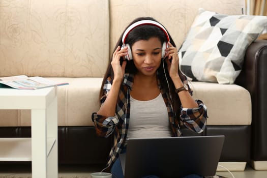 Young African American woman talking on video link in living room at home. Distance learning from home and online communication