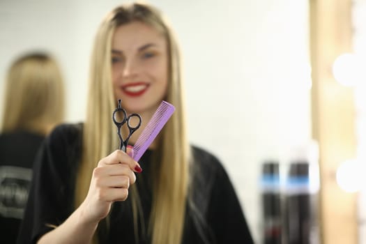 Hairdresser woman holding scissors and comb closeup. Hair styling and care concept