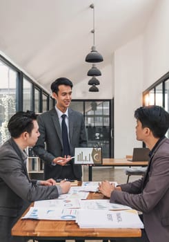 Business People Meeting using laptop computer,calculator,notebook,stock market chart paper for analysis Plans to improve quality next month. Conference Discussion Corporate Concept