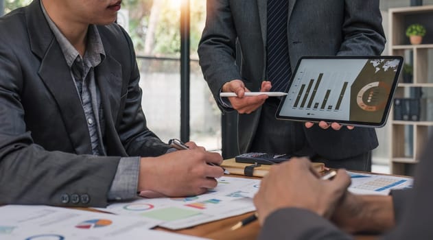 Business People Meeting using laptop computer,calculator,notebook,stock market chart paper for analysis Plans to improve quality next month. Conference Discussion Corporate Concept