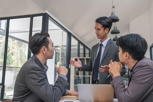 Business People Meeting using laptop computer,calculator,notebook,stock market chart paper for analysis Plans to improve quality next month. Conference Discussion Corporate Concept