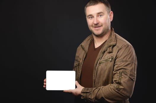 a man holds an electronic tablet with a blank screen in his hands, smiles. handsome man showing blank screen of digital tablet isolated on white background.