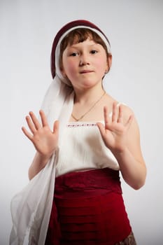 Portrait of Little girl in a stylized Tatar national costume on a white background in the studio. Photo shoot of funny young teenager who is not a professional model