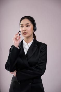 Attractive asian female call center operator with happy smile face advertises job opportunity on empty space, wearing a formal suit and headset on customizable isolated background. Enthusiastic