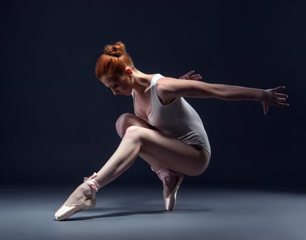 Graceful slender ballerina dancing in studio, close-up