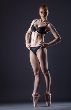 Image of cute skinny red-haired ballerina posing in studio