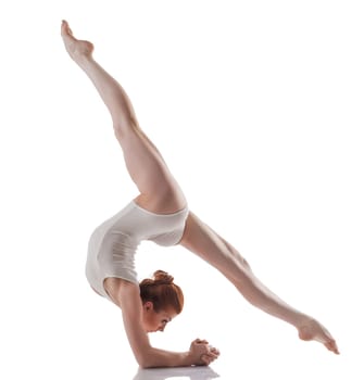 Image of young slender girl doing acrobatic stunt, isolated on white