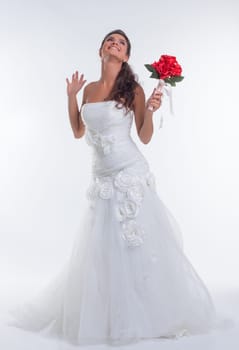 Cheerful young bride posing with bouquet of red flowers