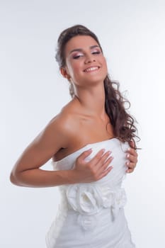 Portrait of happy beautiful bride corrects dress, close-up
