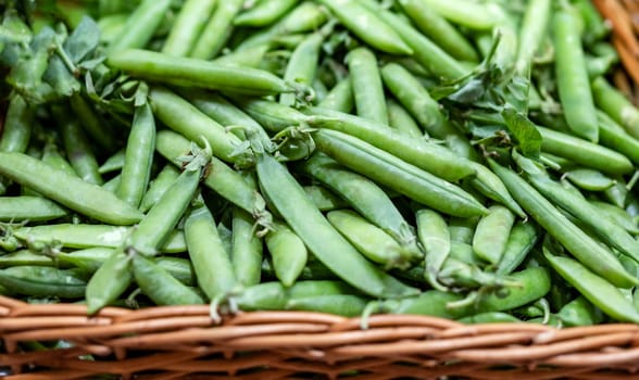 Freshly harvested green peas sold in basket at the farmers market. Organic farmer raw vegetables plant for healthy nutrition