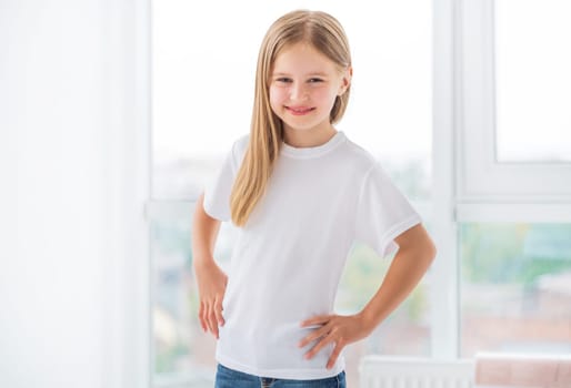 Smiling little girl in white t-shirt in room