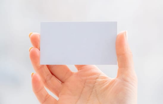 Hand holding empty white business card