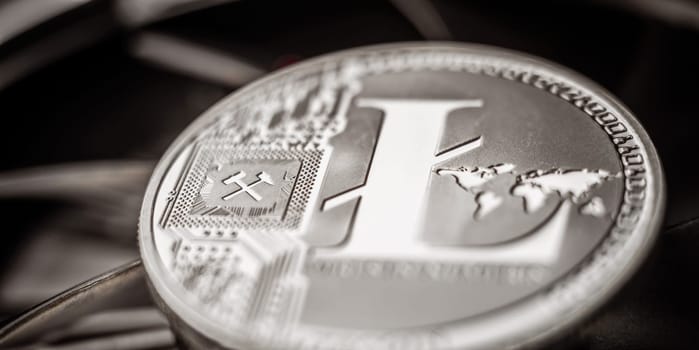 Close-up of physical metal litecoin coin lying on dark background
