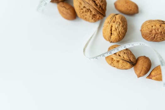 Beautiful whole walnut kernels lie together with a small centimeter, whole nuts in the shell are spilled on the table. Selective focus, noise