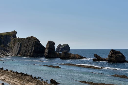 Beach of Liencres, Costa Quebrada, on a sunny day. geological formations, cliffs, no people, lines, cloudless sky