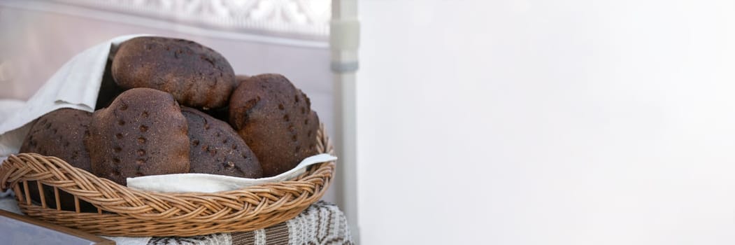 Black fresh homemade bread. A loaf of black rye bread on the counter of a bakery is cut into pieces close-up. Texture of black ecological bread.