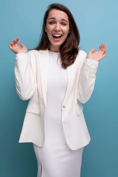 portrait of a well-groomed confident young brunette business woman in a white dress and jacket.