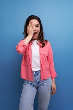 portrait of optimistic brunette young woman in shirt and jeans in studio.