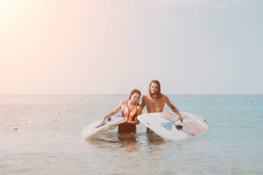 Woman man sea sup. Close up portrait of beautiful young caucasian woman with black hair and freckles looking at camera and smiling. Cute woman portrait in a pink bikini posing on sup board in the sea