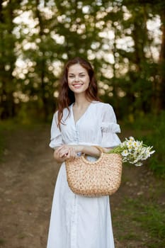 portrait of a beautiful red-haired woman with a wicker bag in her hands, smiling, enjoying a walk in the park. High quality photo