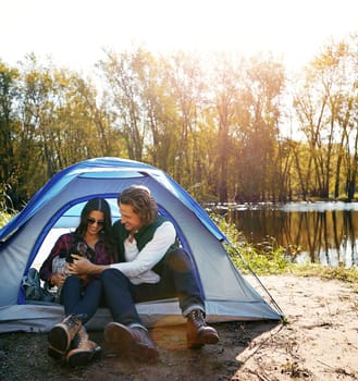 Spending time in the great outdoors together. an adventurous couple out camping with their dog