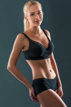 Young beautiful woman in fitness wear trained female body, lifestyle portrait, caucasian model, looking at the camera