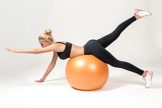 Young blonde woman training with fitball. Fitness exercises