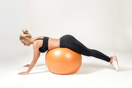 Young blonde woman training with fitball. Fitness exercises