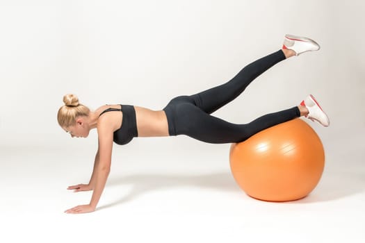 Young blonde woman training with fitball. Fitness exercises