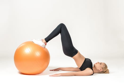 Young blonde woman training with fitball. Fitness exercises