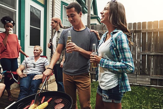 Summer time is cookout time. a group of friends having a barbecue in the yard