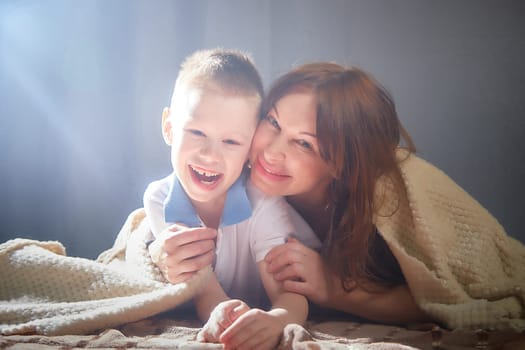 Woman with boy. Mom with son on a white background. Family portrait with mother and boy having fun together