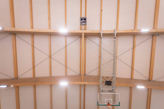 Fraget of the large ceiling of the school sports hall seen from below. All parts of the structure are made of plywood.