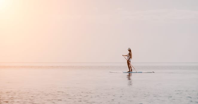 Close up shot of beautiful young caucasian woman with black hair and freckles looking at camera and smiling. Cute woman portrait in a pink bikini posing on a volcanic rock high above the sea