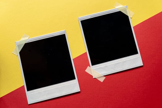 Download Blank photo frames template on red and yellow background. Blank square photo frames with tape on wall copy space. download image