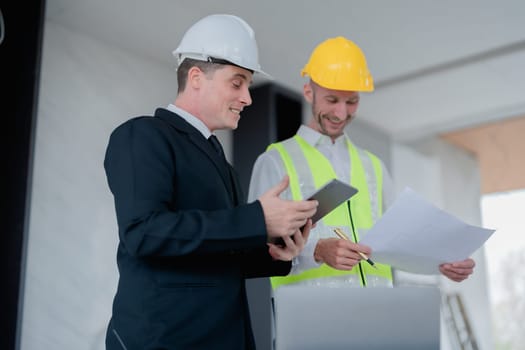 multi ethnic engineer brainstorming and measuring for cost estimating on blueprint and floor plan drawings about design architectural and engineering for houses and buildings.